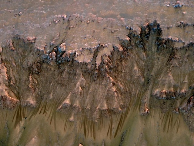 Fotografia powierzchni Marsa. Na stoku widoczne są ciemne wycieki