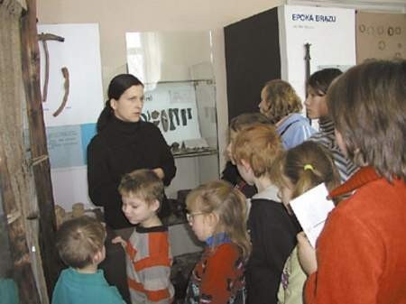 Agnieszka Milka, przewodniczka, pokazuje pałacowe wystawy młodym mieszkańcom Grodźca i Ksawery, uczestnikom Biblioferii.