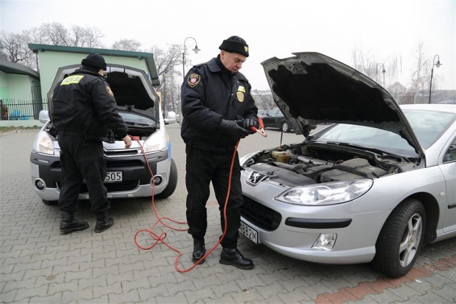 Straż miejska pomaga odpalić auto w Piotrkowie, strażnicy przyjeżdżają z kablami rozruchowymi, które podpinają do akumulatora