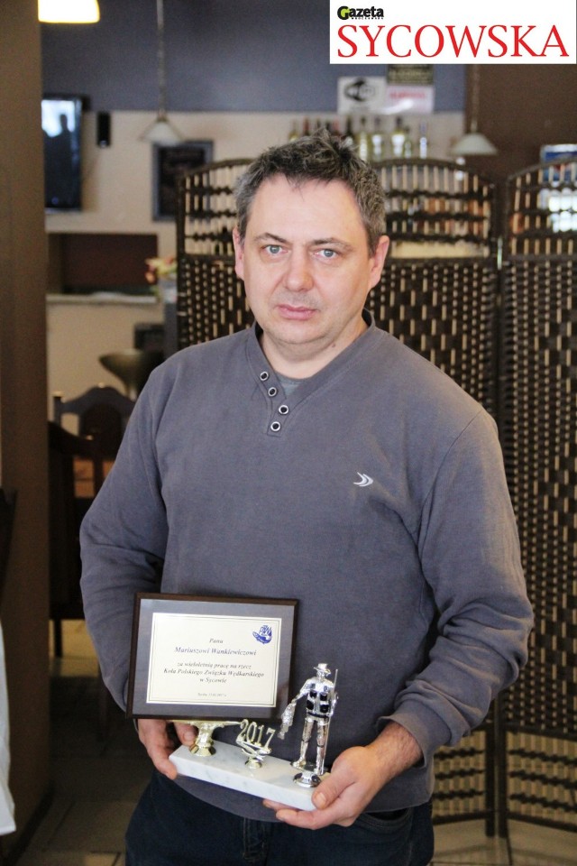 Mariusz Wankiewicz z dyplomem i statuetką będącymi wyrazami podziękowania za wieloletnią pracę na rzecz koła PZW w Sycowie