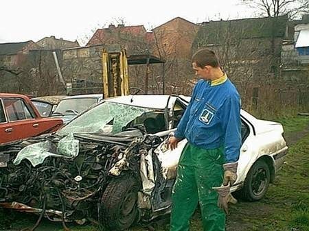 Pracownik autopomocy drogowej pokazuje zniszczone auto; drugie auto nadaje się do kasacji. fot. G. Bielawski