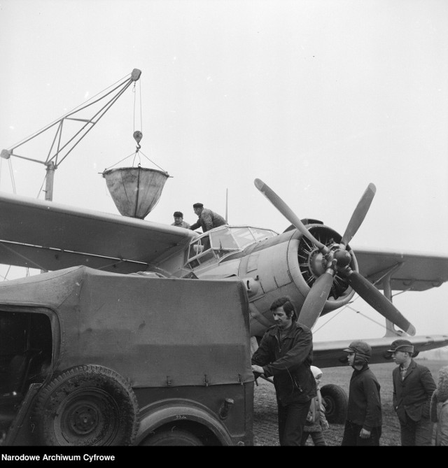 Załadunek nawozów sztucznych do samolotu AN-2R na polu. Na pierwszym planie widoczne dzieci.