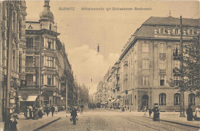 Rozpoczynamy spacer po Gliwicach sprzed lat na Wilhelmstrasse, bo to pocztówka z 1915 roku i tak wówczas obecna ulica Zwycięstwa się nazywała. Acha, i już wówczas były na niej banki ;) 
Po prawej stronie jest widoczny istniejący do dziś budynek - wówczas była to siedziba Śląskiego Związku Bankowego (Schlesiechen Bankverein). Dziś też jest tam bank.