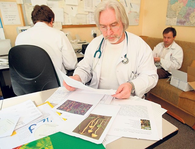 Dr Paweł Czerniak ogląda internetowe wydruki zdjęć grzybów halucynogennych, którymi posługiwał się pacjent.