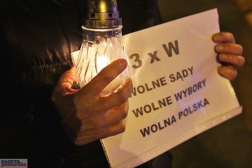 W rękach protestujący mieli zapalone lampki oraz kartki z...