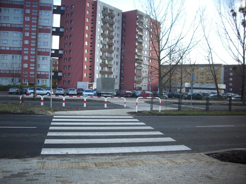 Chodnik, na wyspie rozdzielającej obie jezdnie, biegnie  po...