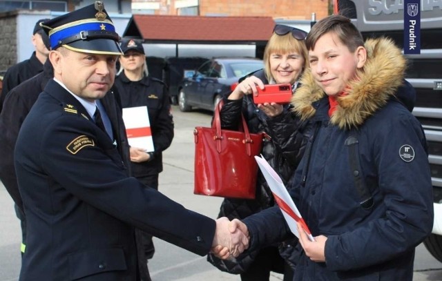 Dominik odbiera list gratulacyjny od komendanta powiatowego PSP w Prudniku
