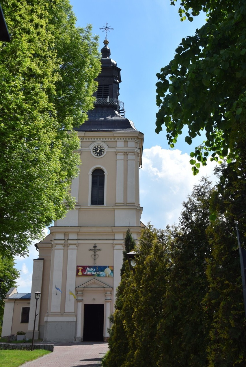 Koźminek. Słoneczny rynek z fontanną, kościół parafialny z...