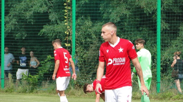 Kacper Przybyłko podczas derbowego meczu Wisły z Cracovią w CLJ U-19 w sierpniu 2022 roku. Z lewej drugi z wiślackich stoperów Jakub Złoch