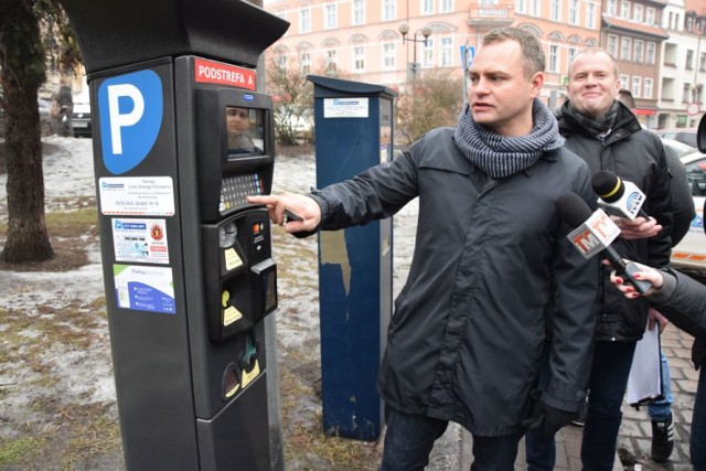 Radosław Wilkiewicz, rzecznik City Parking Group prezentuje nowy parkomat przy Placu Niepodległości