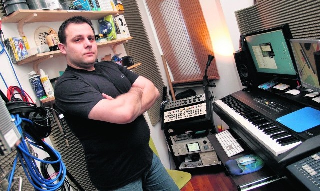 Paweł Grabowski w swojej Kuchni Dźwięku otoczony profesjonalnym sprzętem dźwiękowym i muzycznym