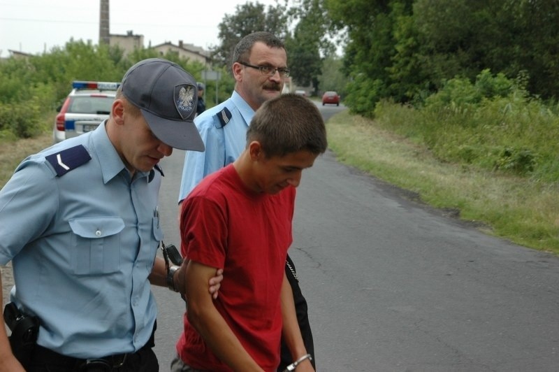 Kamil P. w asyście policjantów podczas wizji lokalnej.