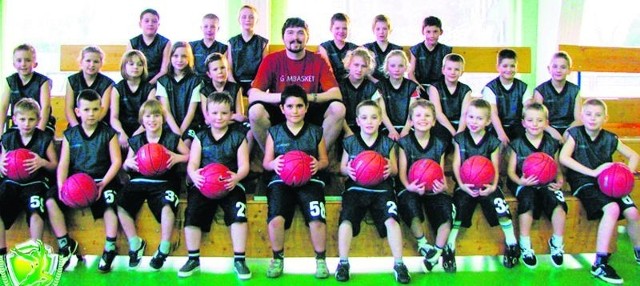 Ubrani w jednakowe młodzi adepci koszykówki ze swym trenerem Rafałem Pasznickim. Do grupy można zapisać się pod numerem tel. 785 51 44