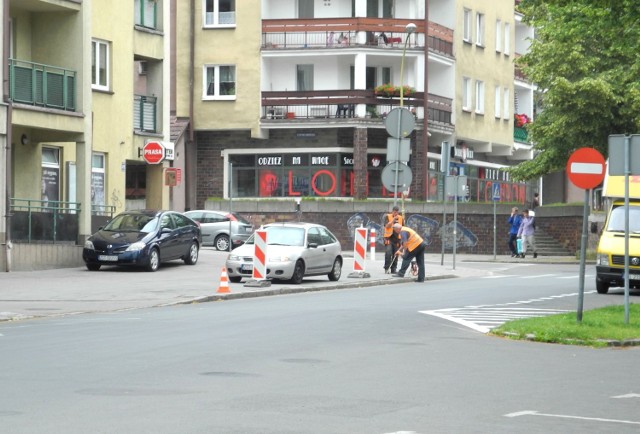 Biało-czerwone stalowe słupki powstrzymujące kierowców przed parkowaniem ustawiano na ulicy Wojska Polskiego. Roboty były utrudnione, bo... na chodniku stały auta.