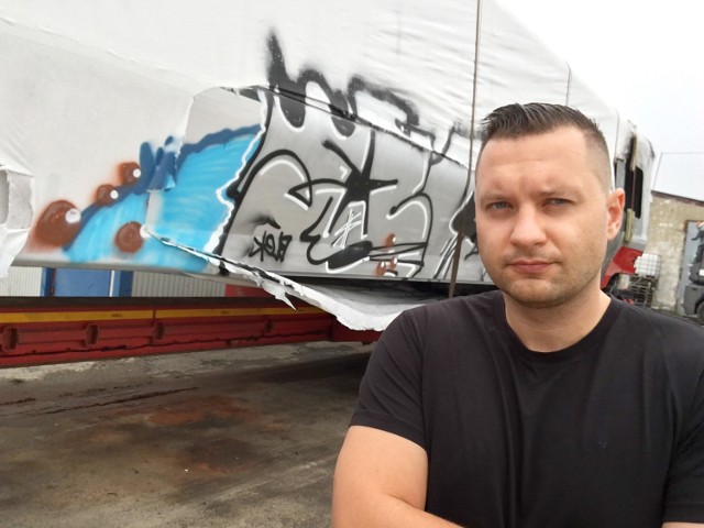 Michał Woch, współwłaściciel Focus Truck Special Transport na tle uszkodzonego wagonu.