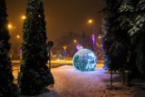 Światełka na ulicach miasta rozjaśniają noc i połyskują w śniegu