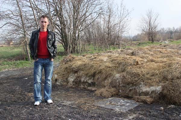 Kamil Bejm, syn właściciela ubojni, stoi obok kompostownika