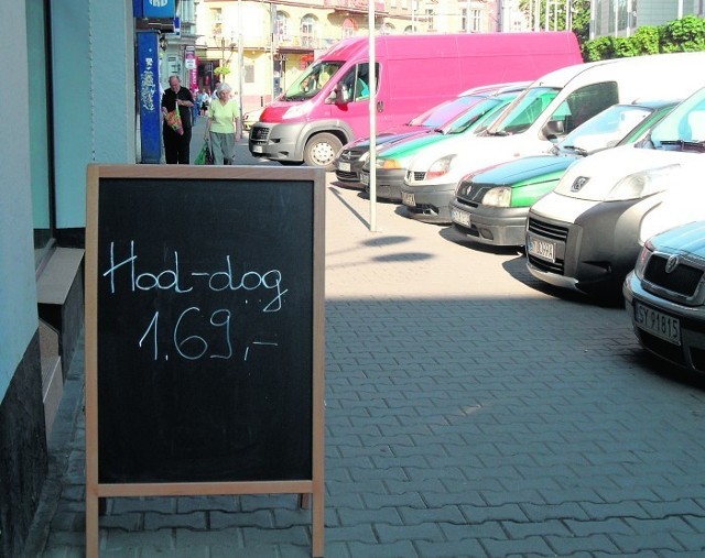 Przed piekarnią - Taką reklamę parówek w bułce zobaczyliśmy przed piekarnią w centrum. Nawet całkiem smaczne. Ale nazwa z "bykiem". Hot-dog to po angielsku "gorący pies". Ale "hod"?