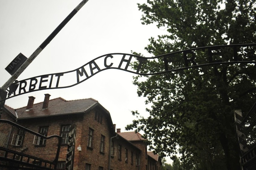 Napis „Arbeit macht frei” - symbol Holokaustu, okrucieństwa,...