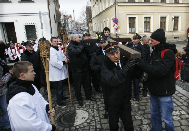 Drewniany krzyż nieśli zmieniający się przedstawiciele parafii