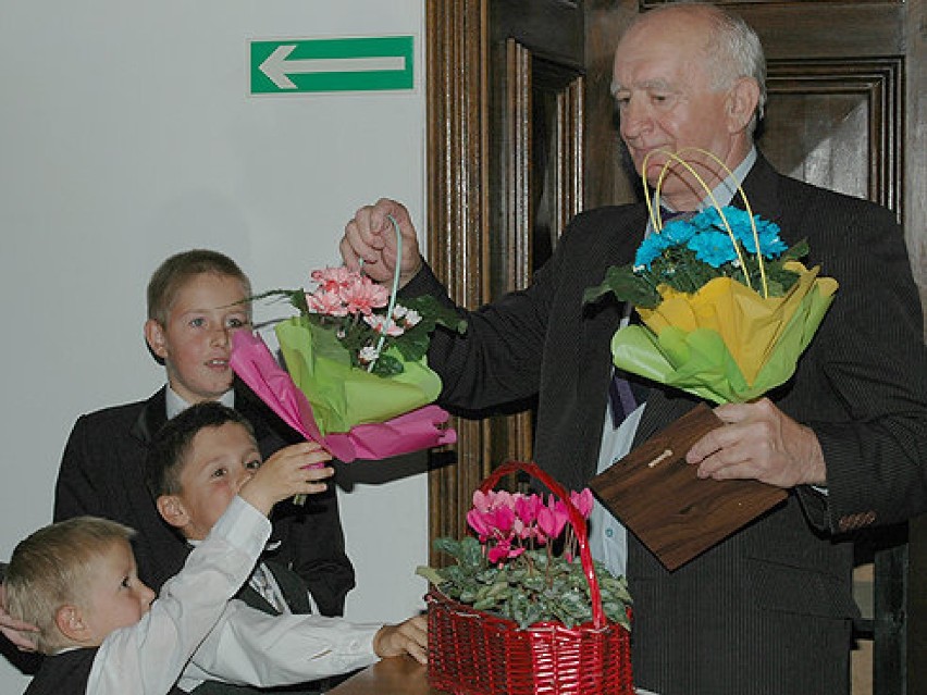 Jubilat podczas wernisażu odbiera kwiaty od najbliższych