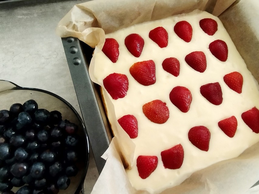 Wylej ciasto na blaszkę wyłożoną papierem do pieczenia. Na...