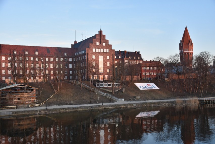 Malbork. Bulwar nad Nogatem zmienia się z dnia na dzień. Uporządkowano skarpę, a napis z nazwą miasta jest odmalowany