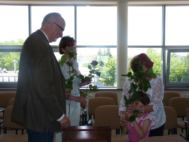Dzieci z rodzin zastępczych wręczają kwiaty przedstawicielowi firmy Jysk, Arturowi Krystyniakowi