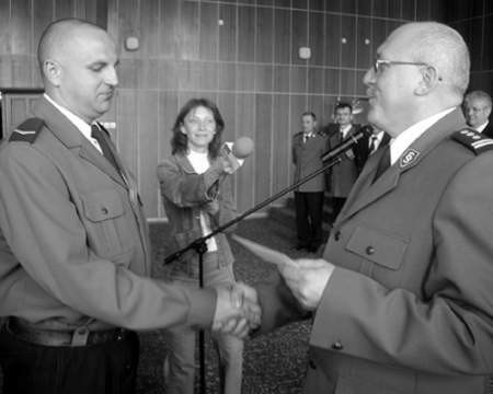 Sierżant Artur Siwek (z lewej) odbiera finansową nagrodę od komendanta wojewódzkiego inspektora Ferdynanda Skiby