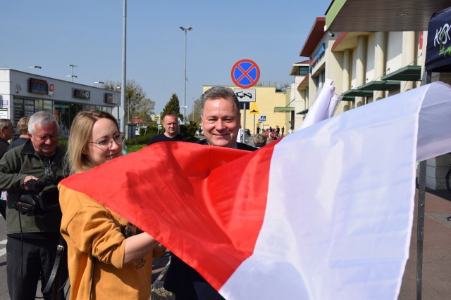 Prezydent Piotr Korytkowski rozdaje flagi przy Galerii nad Jeziorem w Koninie - rok 2022.