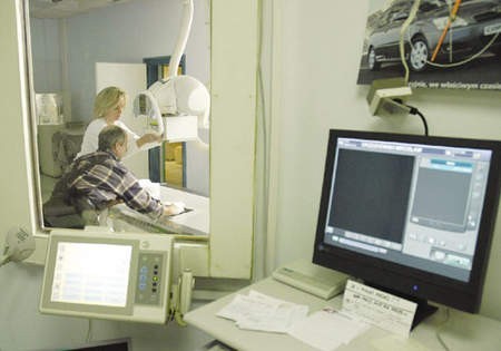 Lucyna Gorczyńska, technik RTG, wykonuje prześwietlenie dłoni pacjenta, który stłukł ją sobie na budowie. Za ok. 30 sekund zdjęcie pojawi się na monitorze komputera, gdzie zostanie wstępnie opisane. Potem otrzyma je lekarz w sąsiednim pokoju i tam dokładnie je przejrzy.