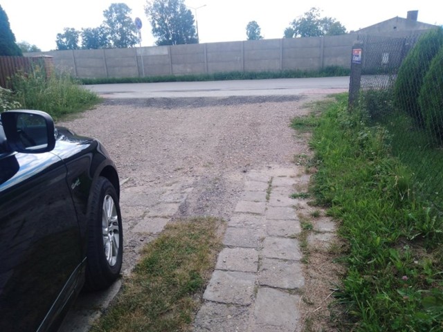 Zdjęcie drogi wjazdowej do ulicy Cynkowej do ulicy Porannej. Widoczny uskok przy wjeździe na drogę.