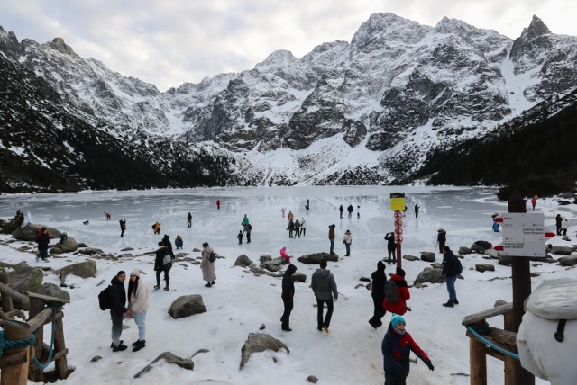 Turyści na tafli lodu na jeziorze Morskie Oko w Tatrach.