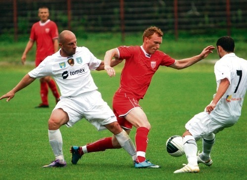 Marcin Radzewicz (w środku) walczy o piłkę z graczami Ruchu.