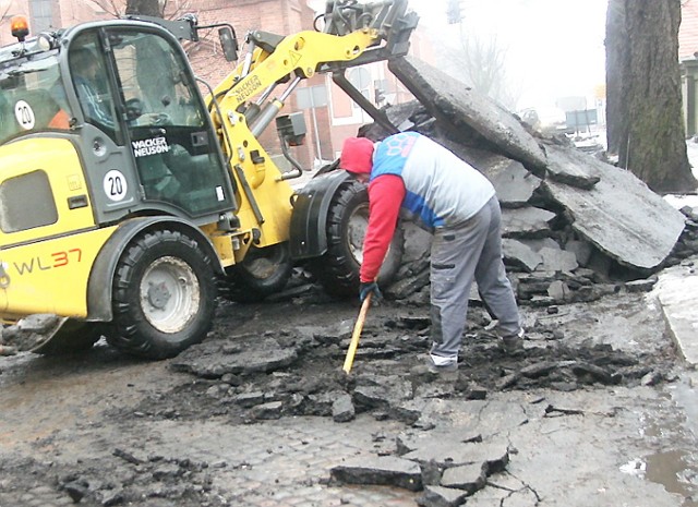 Pracownicy firmy "MegaStyl" zdejmują asfaltową nawierzchnię ulicy Tumskiej