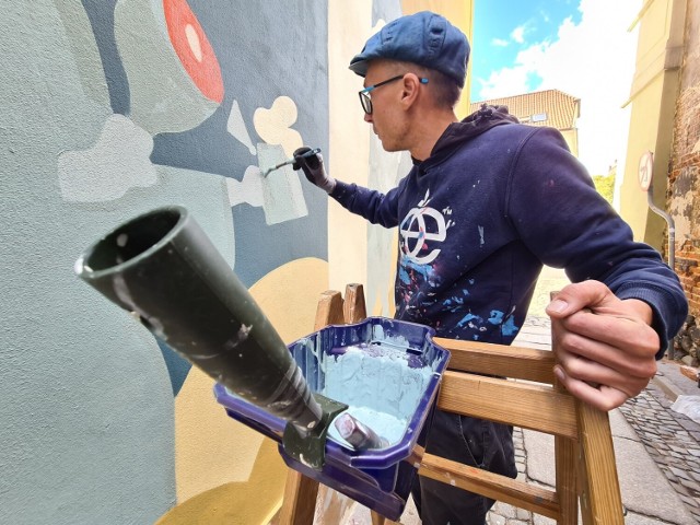 Przy ul. Ciasnej w Toruniu trwają prace nad nowym muralem. Znikną wulgaryzmy, które od lat "upiększały" jedną z najbardziej znanych uliczek starówki. Autorem muralu jest Andrzej Poprostu, toruński artysta.