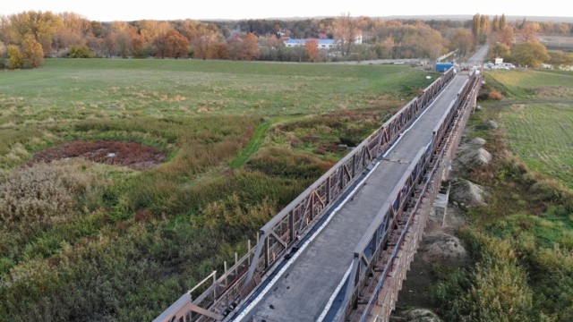 Jeszcze w tym roku kierowcy wjadą na wyremontowany stary most w Cigacicach. Na ten moment z niecierpliwością czekają mieszkańcy okolicznych miejscowości, którzy muszą nadkładać drogi, aby przedostać się na drugi brzeg Odry.

Prace remontowe rozpoczęły się 15 kwietnia 2020 r., miały zakończyć się w listopadzie. Dziś wiadomo, że ostatecznym terminem zakończenia robót jest grudzień. 

Najważniejsze prace zostały już wykonane. Stalowe elementy wypiaskowano i  odnowiono. Rozebrane i wymienione zostały płyty pod jezdnią oraz niektóre elementy konstrukcyjne. Na całej długości wylany jest już beton, a wkrótce, po położeniu asfaltu, cała nawierzchnia zmieni kolor na czarny.  

Po remoncie most będzie mieć nośność 16 ton. Ruch jednak będzie odbywał się wahadłowo. To ze względu na szerokość przeprawy, na której większe pojazdy mijałyby się z trudem. 

Koszt renowacji wynosi ok. 12 mln zł. 

Zobacz także: Tak wyglądał drewniany most w Cigacicach

Wideo: Tak wyglądał most przed rokiem
