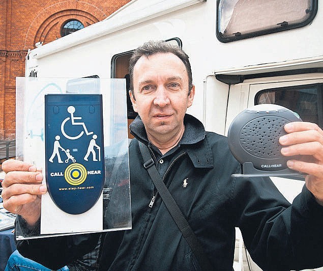 Zdzisław Walicki prezentuje urządzenie, które może być montowane np. przed wejściem do sklepu, by niewidomy mógł poprosić obsługę o pomoc.