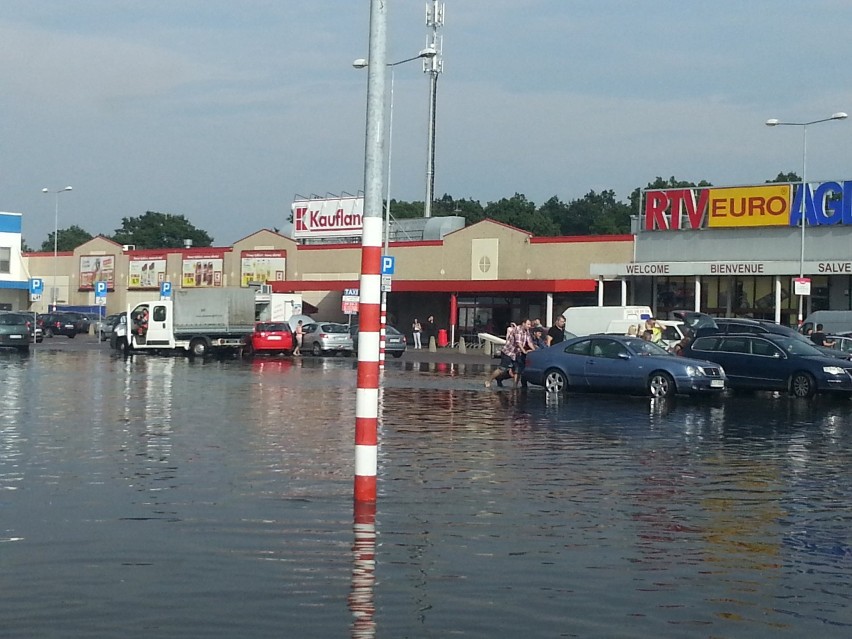 Opady deszczu unieruchomiły wiele pojazdów na parkingu centrum handlowego.