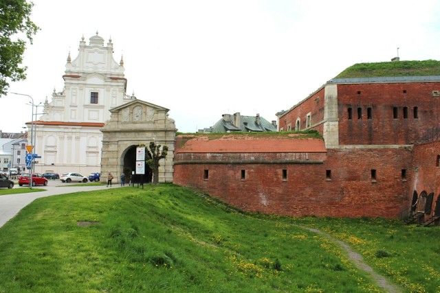 Na pierwszym planie zamojska Stara Brama Lwowska oraz dawne, miejskie fortyfikacje