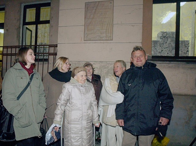 Kazik Staszewski i jego rodzina przed pamiątkową tablicą na budynku szkoły