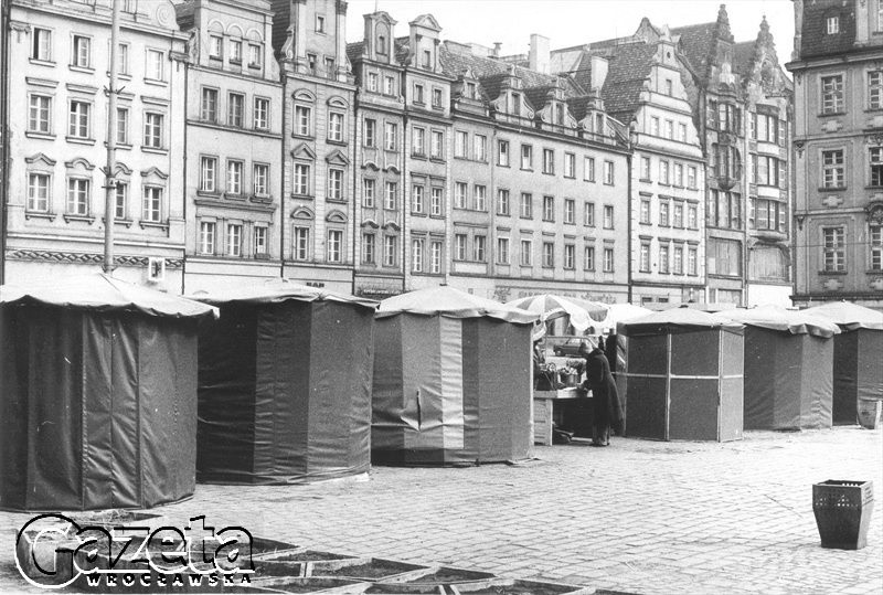 ROK 1985. RYNEK, STOISKA KWIATOWE NA TLE ŚCIANY PÓŁNOCNEJ.