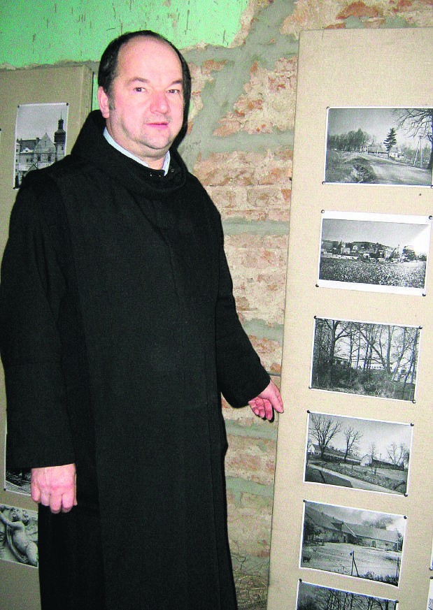 Przeor Damian Wasylewicz przy historycznych zdjęciach klasztoru