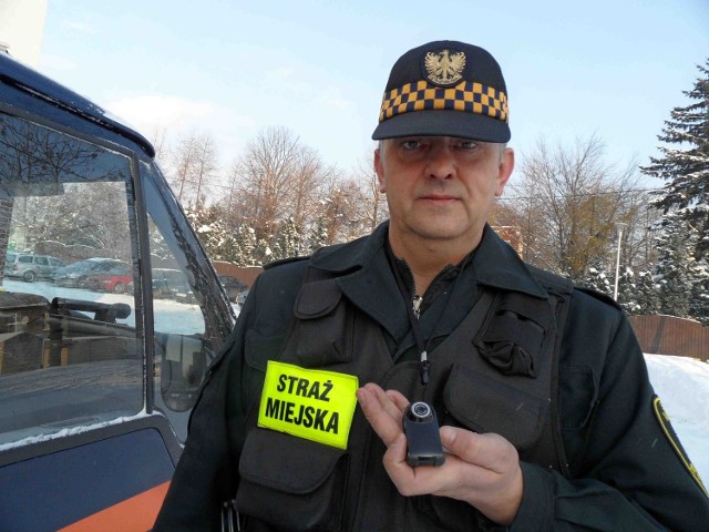 Strażnik Rafał Jarmusz przypina kamerę do kieszeni kurtki