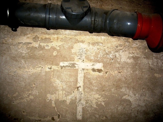 W jednej z byłych cel w piwnicach pozostał na ścianie krzyż wyżłobiony przez więźniów