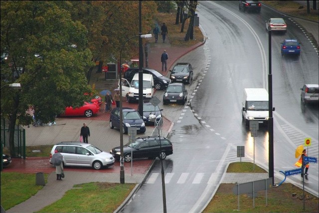 Samochody stoją na chodniku i w zatoce autobusowej