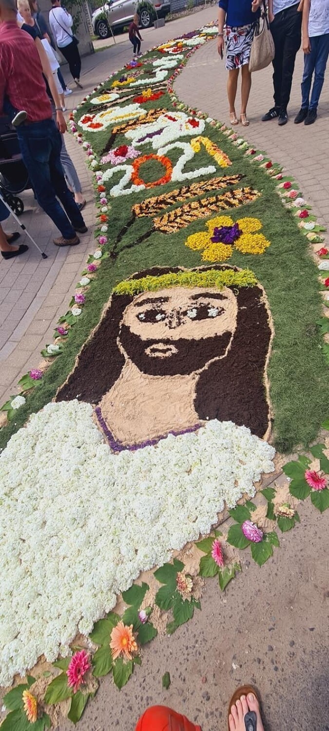 Wizerunek Chrystusa na dywanie kwiatowym.