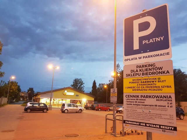 Tablice informujące o konieczności pobrania biletu pod parkingiem