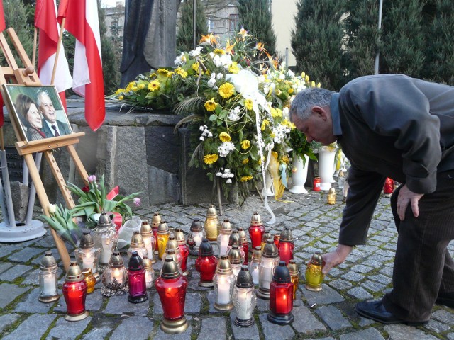 Bełchatowianie zapalają znicza pod zdjęciem pary prezydenckiej