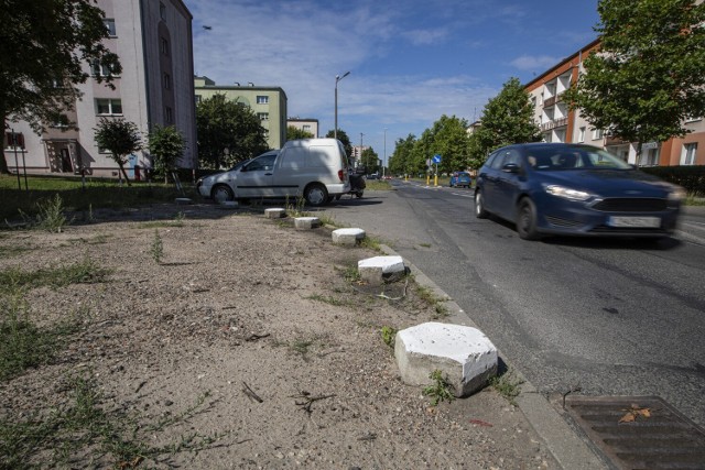 Coraz częściej kierowcy wybierają na dzikie miejsca parkowania samochodu bydgoskie trawniki i tereny zielone. W niektórych miejscach miasta to już prawie plaga. Zgłoszeń do straży miejskiej jest coraz więcej, tak samo jak mandatów i wniosków do sądu. Na zdjęciu: wyjeżdżone przez parkujące w tym miejscu samochody "klepisko" przy ul. Powstańców Wlkp. - teraz ogrodzone betonowymi trylinkami.